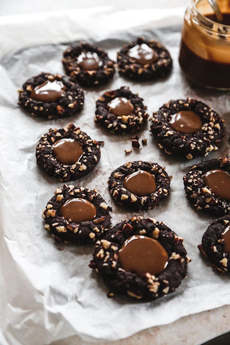These turtle thumbprint cookies complete with a gooey caramel center and pecan coating. Try not to eat five? | cookingwithparita.com
