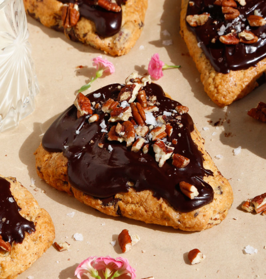 close up image of vegan chocolate pecan scones with fudgy chocolate frosting