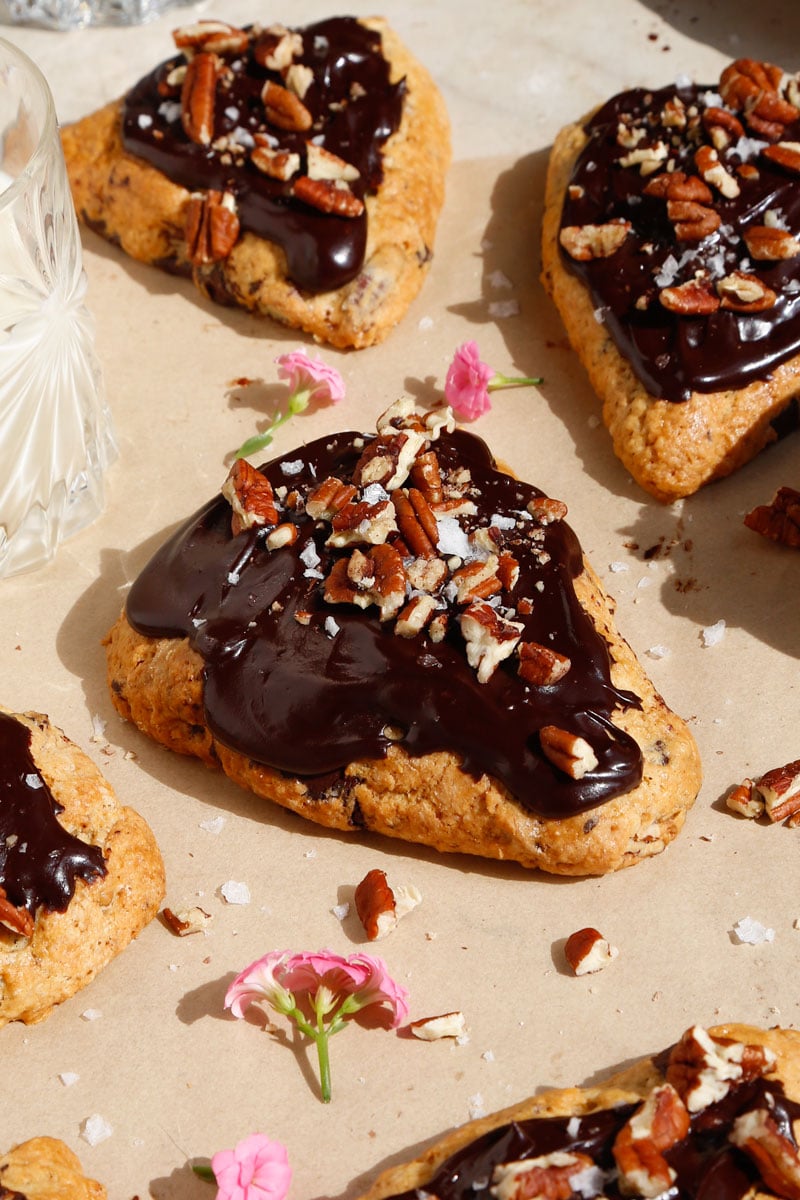 close up image of vegan chocolate pecan scones with fudgy chocolate frosting