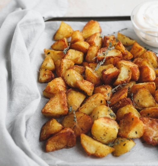 Angled image of Crispy Roast Potatoes with Garlic & Thyme | cookingwithparita.com