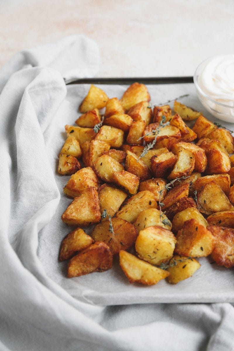 Angled image of Crispy Roast Potatoes with Garlic & Thyme | cookingwithparita.com