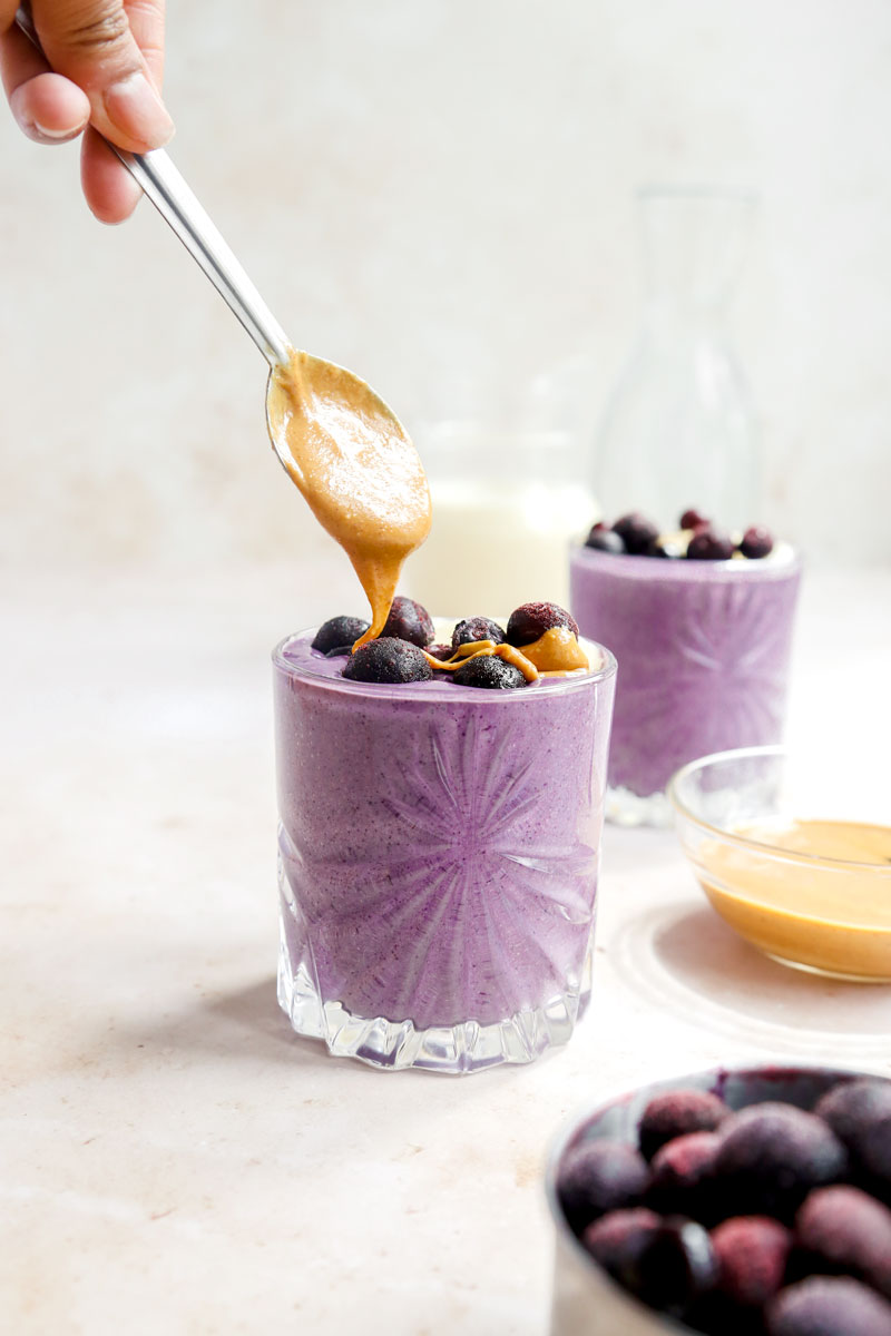 Vegan Peanut Butter Blueberry Banana Smoothie, topped with blueberries and a drizzle of peanut butter | cookingwithparita.com