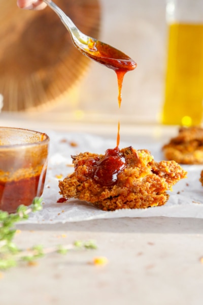 Image of vegan chicken being drizzle with hot maple sauce