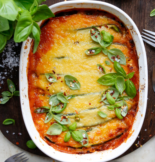 Image if vegan zucchini lasagna topped with fresh basil and chili flakes
